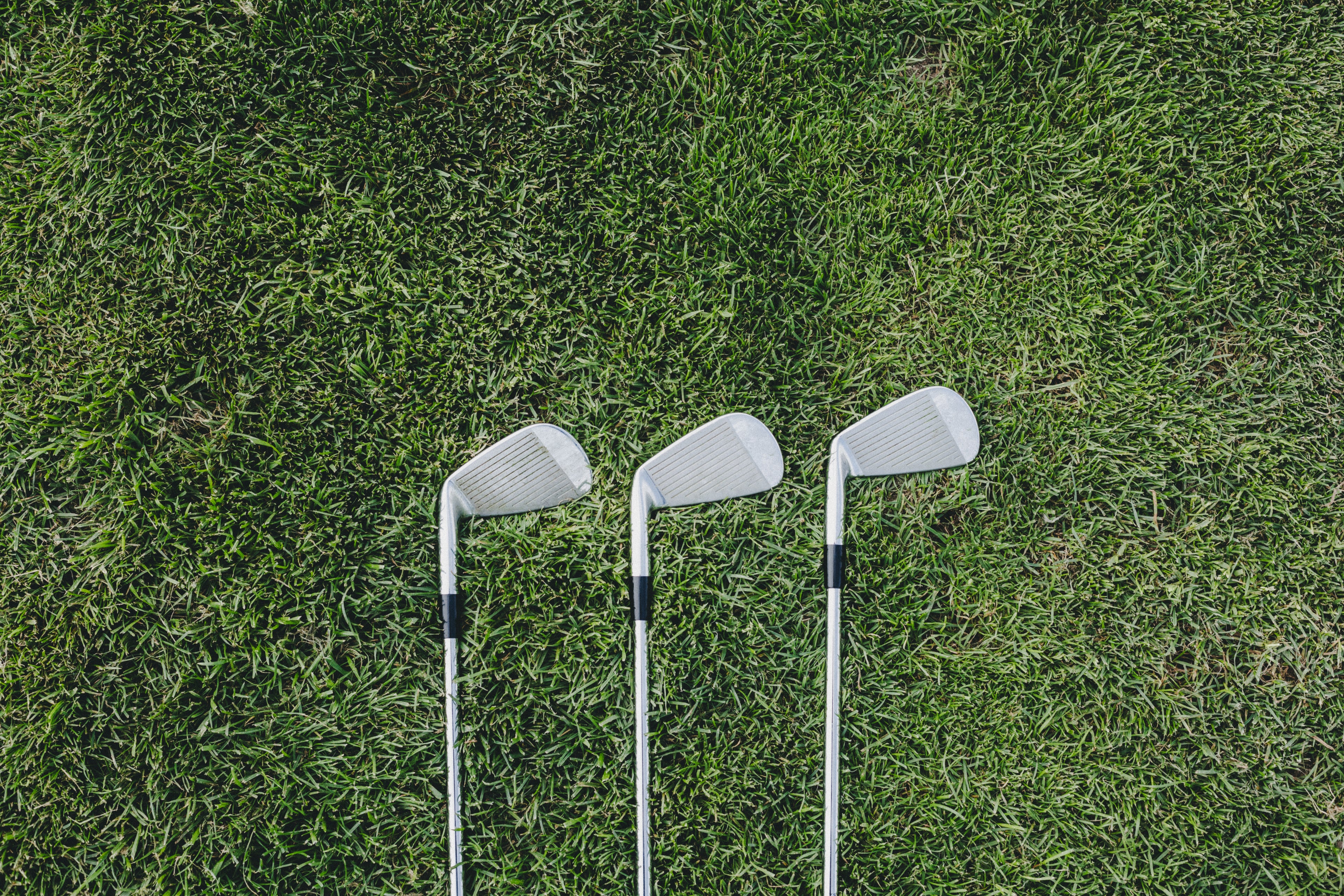 Three Golf clubs on grass