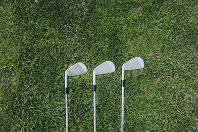 Three Golf clubs on grass